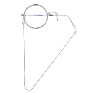 Detail of silver monocle frame with vintage metal chain and white pearl accent