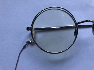 Detail view of retro silver monocle with snake chain and natural cat eye stone
