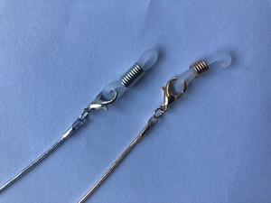 Macro detail of gold and silver snake chains with lobster clasps and silicone loops