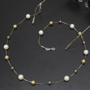 Chaîne de lunettes dorée élégante avec perles et billes mates sur fond noir