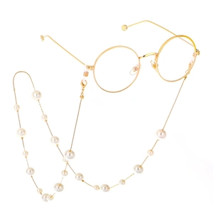 Fashionable gold glasses chain with pearls and vintage round frame glasses on white background