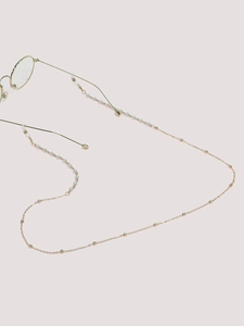 Detailed shot of golden eyewear chain with white pearls and silicone non-slip loops