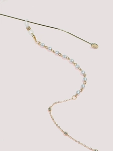 Detail of elegant gold glasses chain with white pearls and rubber anti-slip loops