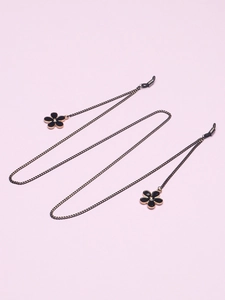 Détail d'une chaîne de lunettes avec breloques de fleurs noires et finitions dorées