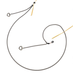 Chaîne de lunettes noire avec pendentif cœur ajouré et détails dorés sur fond blanc
