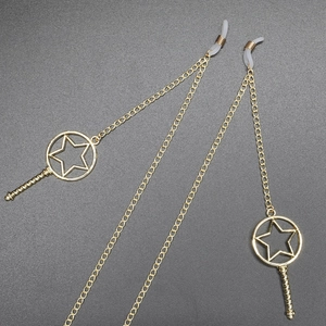 Golden eyewear chain featuring star charms and anti-slip silicone loops on grey surface