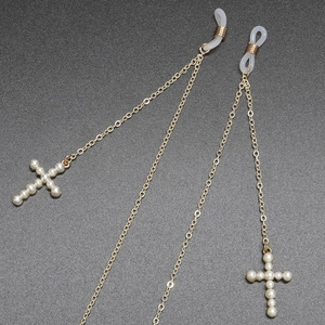 Golden anti-slip eyewear chain with faux pearl cross pendant on textured dark surface