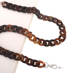 Macro detail of amber tortoiseshell acrylic glasses chain with silver lobster clasp