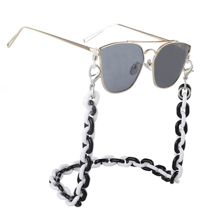 Classic gold aviator sunglasses with a bold black and white acrylic eyewear chain
