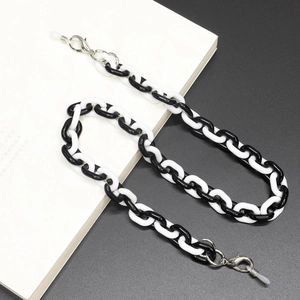 Close-up of black and white acrylic eyewear chain with silver lobster clasps and silicone loops