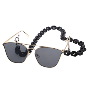 Detail of chunky black acrylic link chain attached to gold rimmed sunglasses