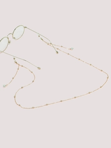 Close-up of golden glasses chain with metal beads and white faux pearl charms