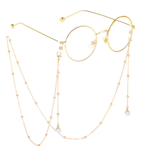 Golden round glasses frame with fine pearl eyewear chain on a white background
