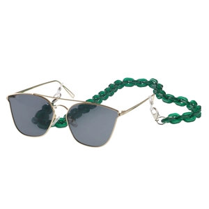 Detail of green chunky acrylic chain attached to gold metal sunglasses on white background