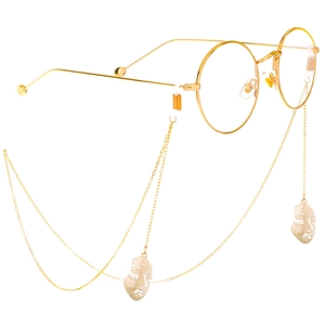 Gold round frame glasses featuring hanging metal chains and abstract face pendants