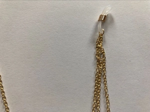 Détail macro de la chaîne de lunettes dorée avec boucles en silicone antidérapantes