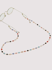 Détail des perles colorées sur une chaîne de lunettes dorée aux maillons fins