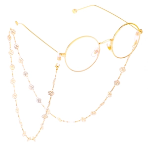 Lunettes rondes dorées avec chaîne à fleurs de rose évidées vintage sur fond blanc