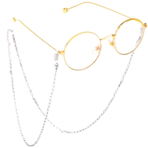 Lunettes rondes dorées avec chaîne en acier inoxydable argenté sur fond blanc épuré