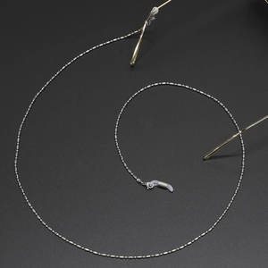 Silver beaded stainless steel glasses chain with silicone loops on grey background