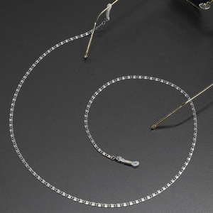 Silver stainless steel eyeglass chain with anti-slip silicone loops on dark background