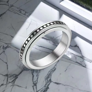 Detail of 6mm stainless steel spinner ring with black contrast band on marble surface