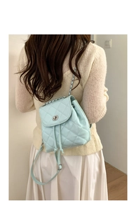 Mint green quilted mini backpack with silver metal twist lock shown on a model