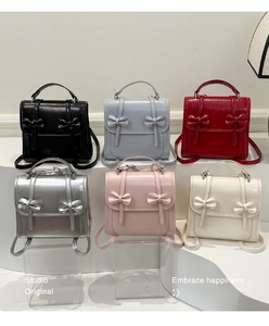 Seis mini mochilas brillantes de varios colores con detalle de lazo en escalones blancos