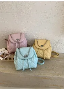 Detailed view of quilted mini backpacks in pink, blue, and yellow with metal chain straps