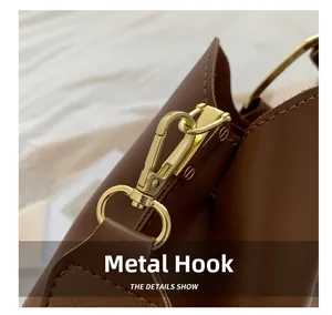 Close-up of premium golden metal hardware hook and stitching on brown leather bag