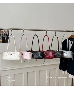 Detail showing various colors of shoulder bags with bow ties and heart metal pendants