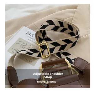 Detail of adjustable woven strap with geometric pattern and gold hardware on brown leather bag