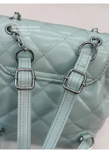 Detailed view of adjustable shoulder straps on mint green quilted backpack with silver buckles