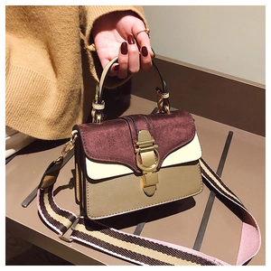 Close-up of retro multi-color patchwork handbag with textured suede and gold metal clasp