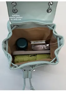 Interior view of quilted blue leather backpack showing storage for phone and umbrella