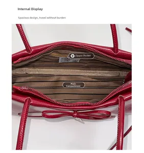 Detail view of the red glossy handbag showing striped lining and internal zipper pocket