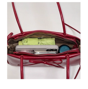 Top view of red patent leather shoulder bag showing spacious interior with daily essentials