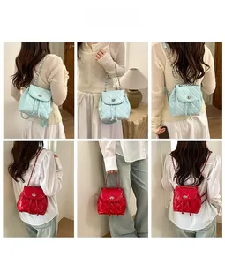 Quilted backpack with chain straps in red and light blue shown on a fashion model
