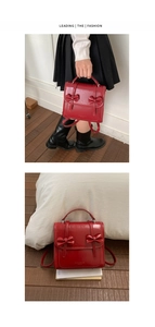 Detalle del bolso de cuero rojo brillante con lazos y correas de mochila ajustables