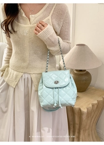 Detailed close-up of light blue quilted mini backpack with glossy finish and silver turn-lock