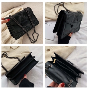 Detail of black studded crossbody bag with chain strap and multiple interior compartments
