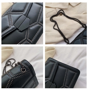 Macro detail of black matte leather square bag with silver rivets and gunmetal chain