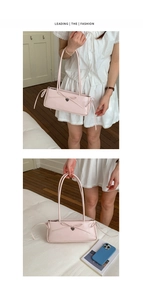 Detail of elegant pink bow handbag with silver heart charm and shoulder strap