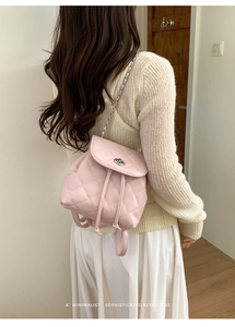 Detail of pink quilted mini backpack with silver twist lock and woven chain strap