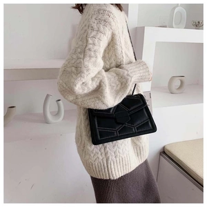 Detail of black quilted leather shoulder bag with rivets and elegant metal chain strap