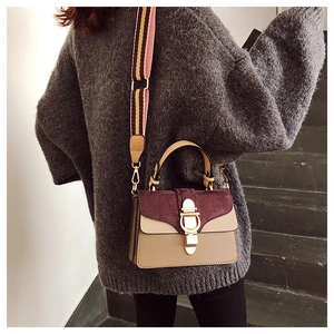 Retro color-block handbag with burgundy suede and striped wide strap on female model