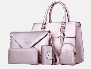 Detail of five-piece lavender faux leather handbag set with gold hardware accents