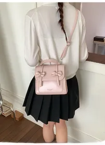Detalle del bolso rosa con lazos en cuero PU y correa ajustable para uso diario