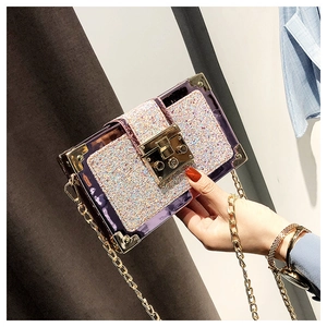 Detail of purple sequin box bag with gold metal corners and chain strap