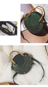 Dettaglio borsa rotonda verde scuro con manico in metallo retrò e spazio interno